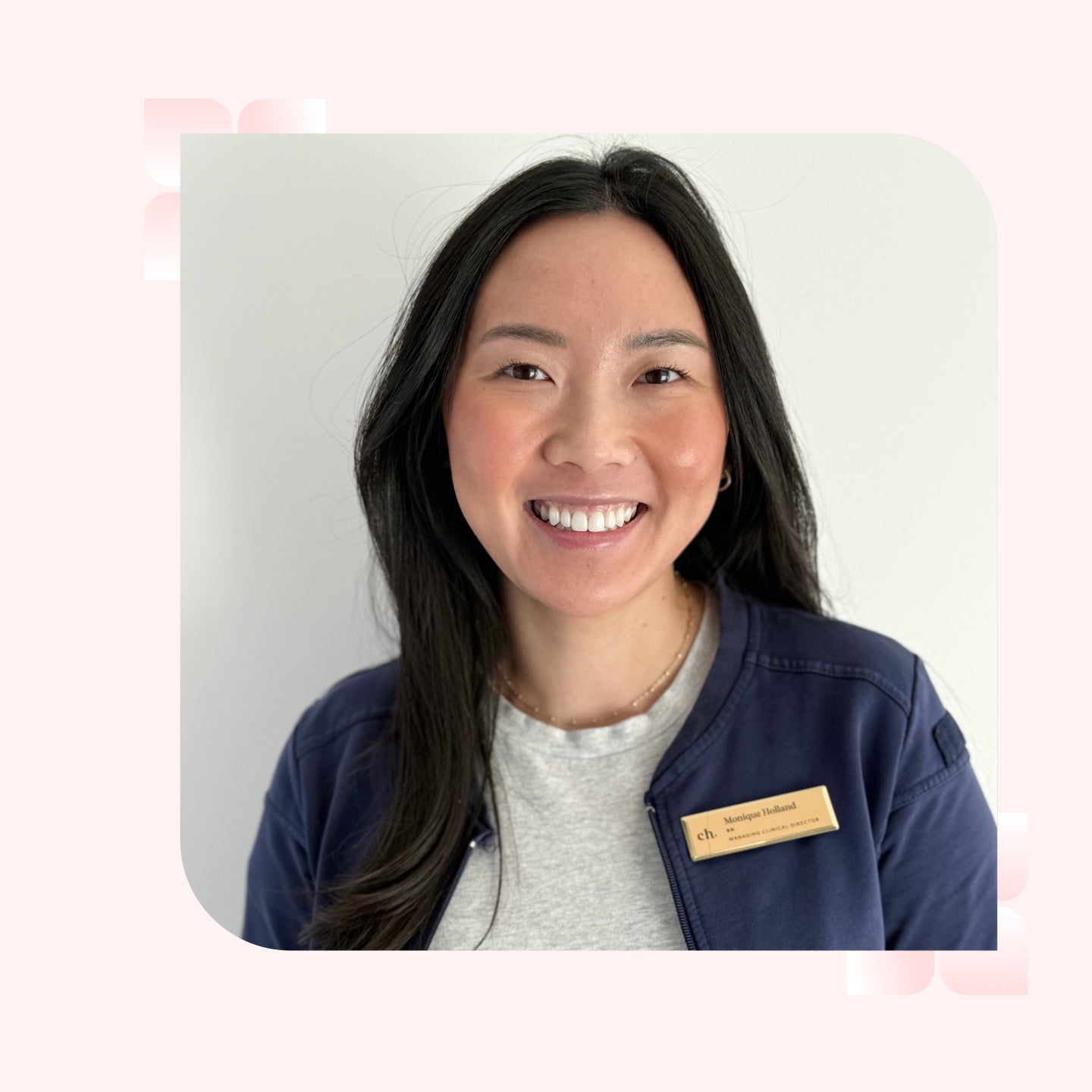 A headshot of a smiling woman with long black hair