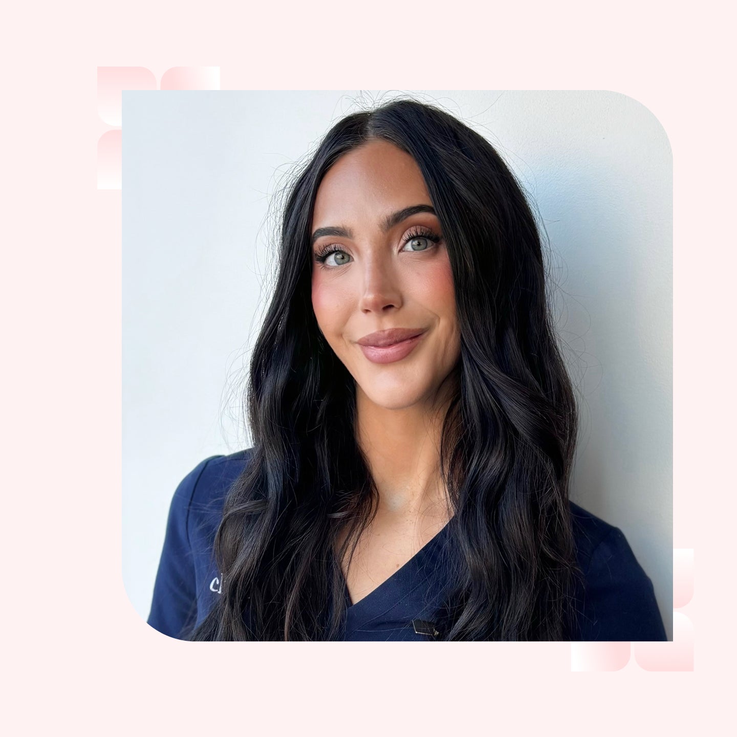 A headshot of a woman with long, wavy brown hair smiling
