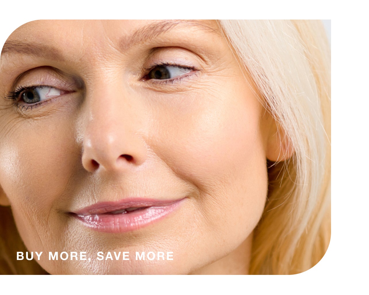 A close up of a smiling woman's face, with glowing skin and glossy lips, overlaid with text which reads "Buy more, save more"