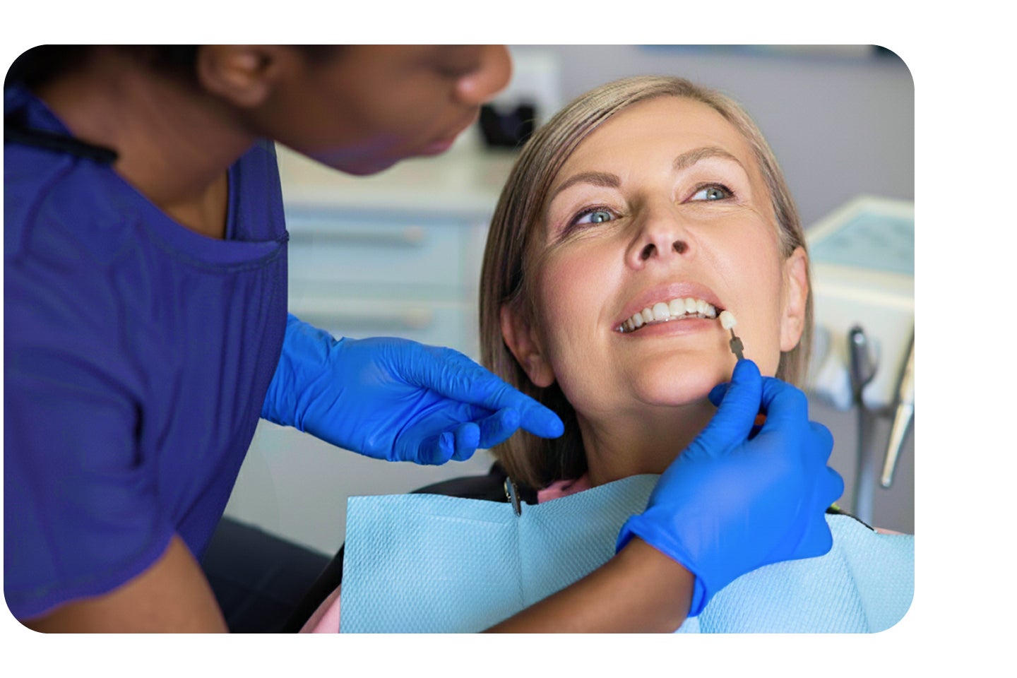 A dentist examining a female patient’s teeth during a dental veneers consultation, showcasing personalized cosmetic dentistry care and a confident smile.