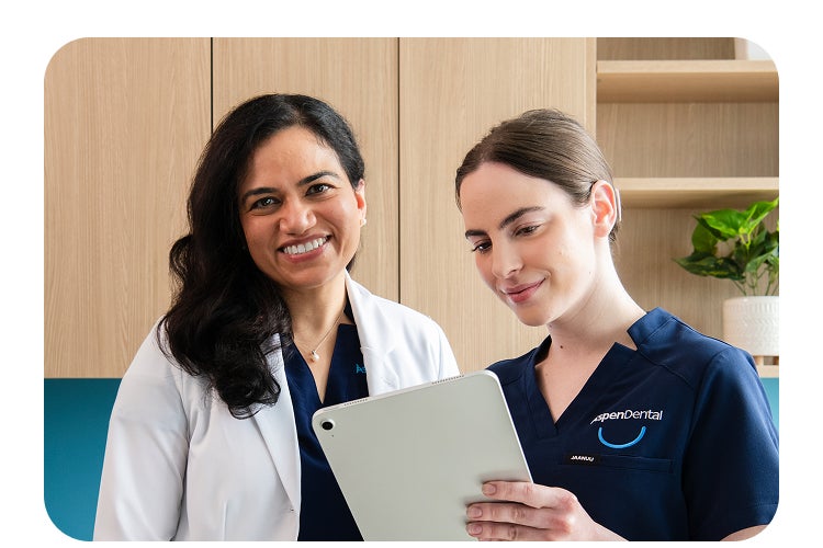 Two Aspen Dental providers collaborating on a tablet, symbolizing the strength of Aspen Dental partnerships in supporting providers and patients.