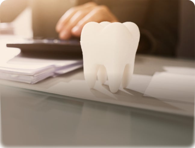 Tooth model on desk with overlay text: “Single tooth implants. Lasting solution, real value.”