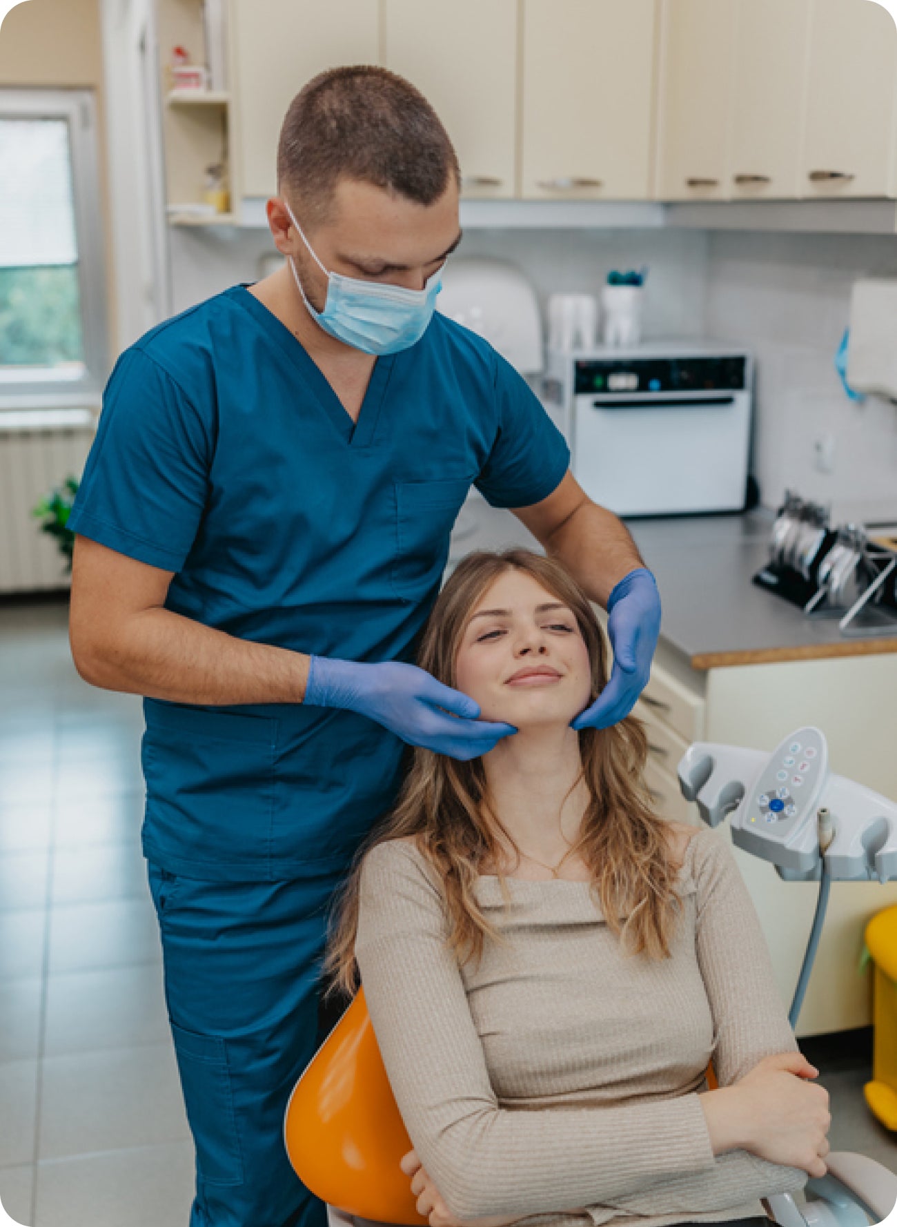 Dentist examining a patient’s jaw in a dental office, suggesting face numbness or tingling near a painful tooth.