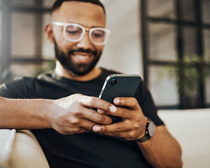 Someone looking at their smart phone setting up a WellNow appointment.