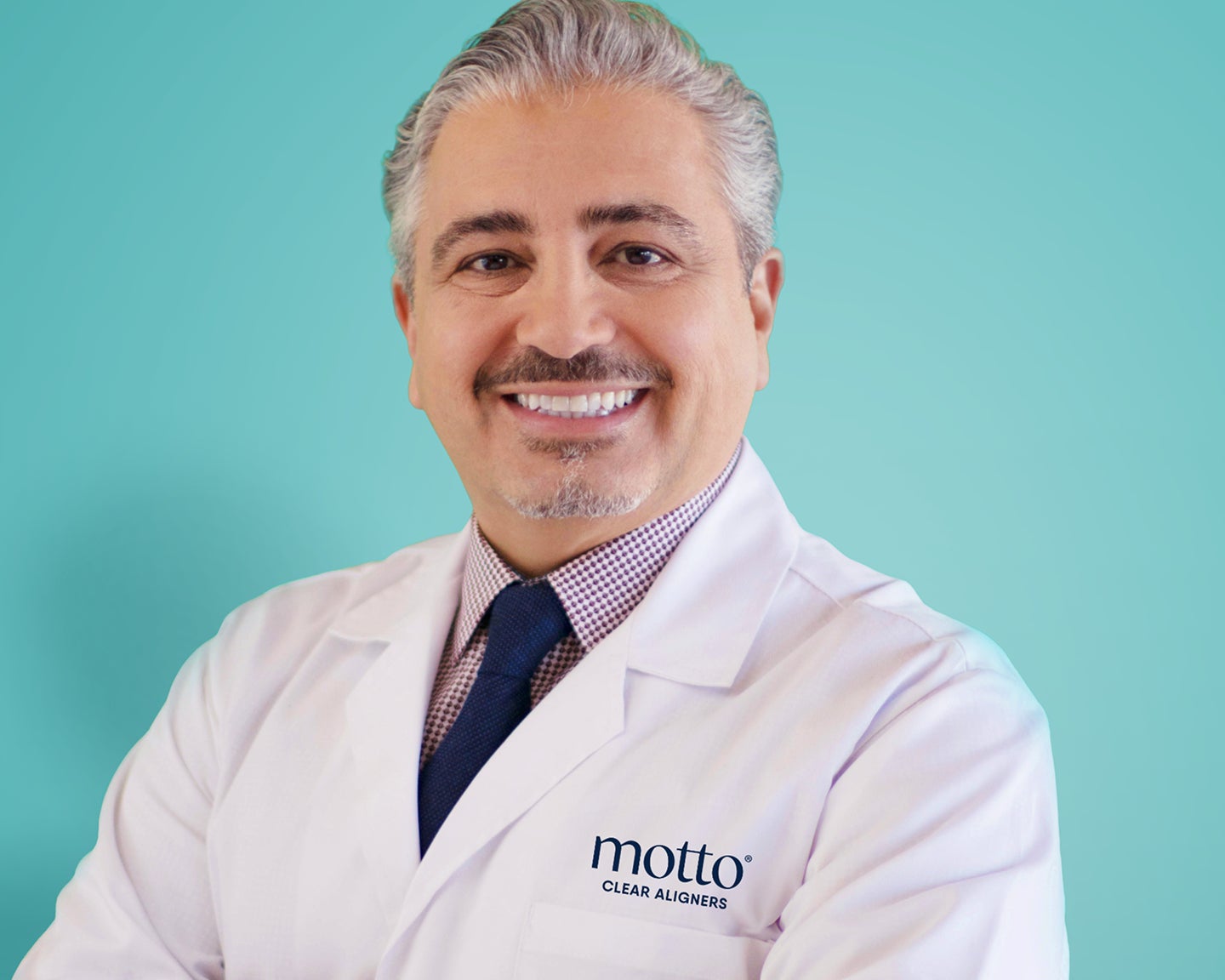 Smiling male dentist in a white coat alongside a quote about patient-centered care and listening.