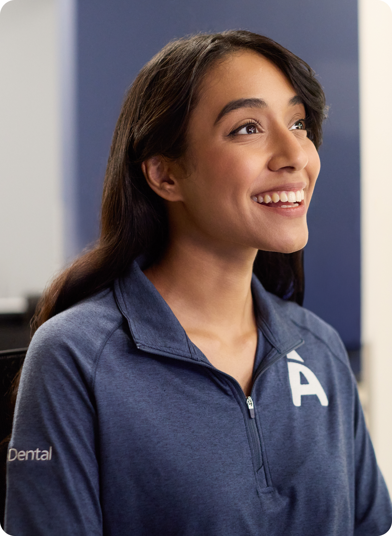 A smiling woman in a dental polo shirt