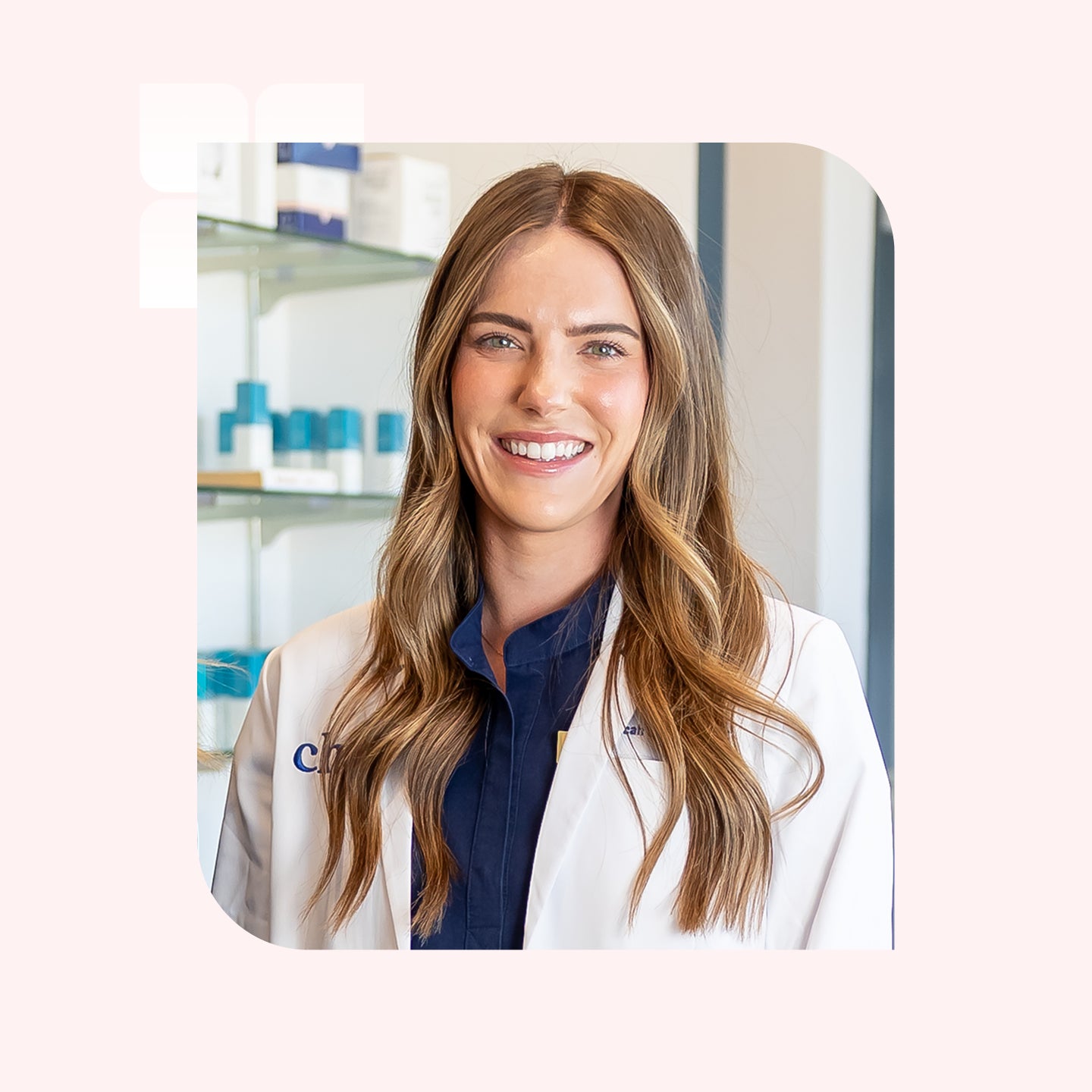 A smiling woman with long blonde hair wearing a white lab coat in Chapter Aesthetic Studio