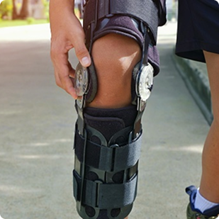 Person adjusting a knee brace on their leg