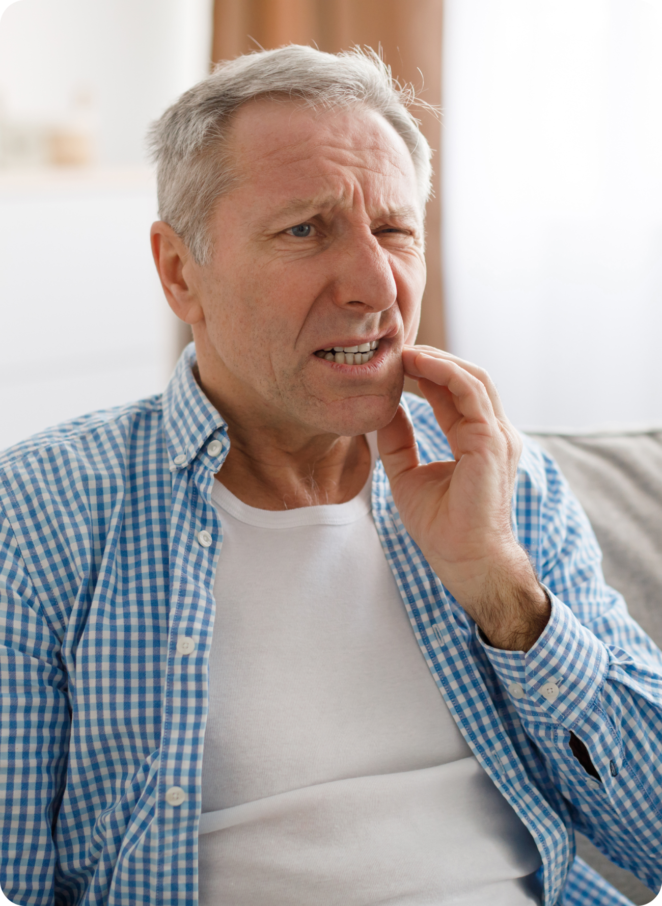 Man touching his cheek with a concerned expression, suggesting concern about whether an over-the-counter temporary filling can trap an infection in a tooth.
