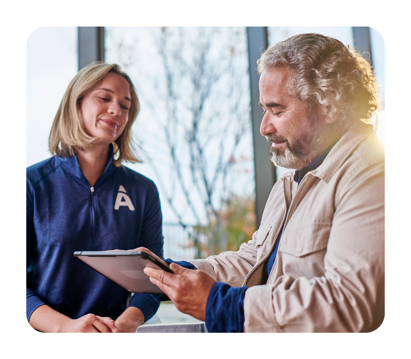 A male patient at Aspen Dental is shown a treatment plan on a tablet by a female Aspen Dental team member.