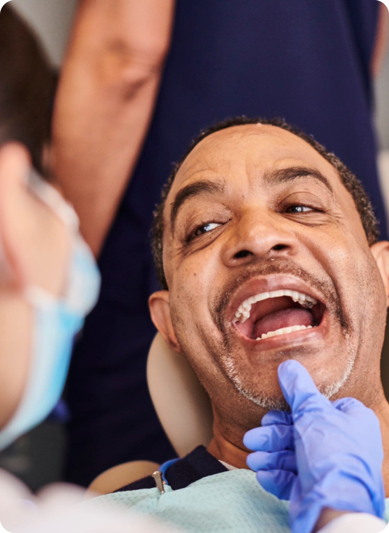 A man in a dental chair with his mouth open
