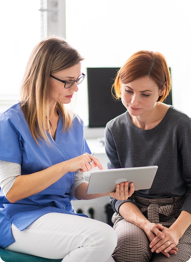Dental professional explains gum disease symptoms to a patient using a model. Focus on identifying early warning signs.
