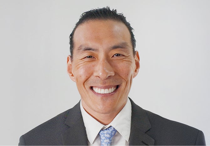 Professional headshot of a smiling man.