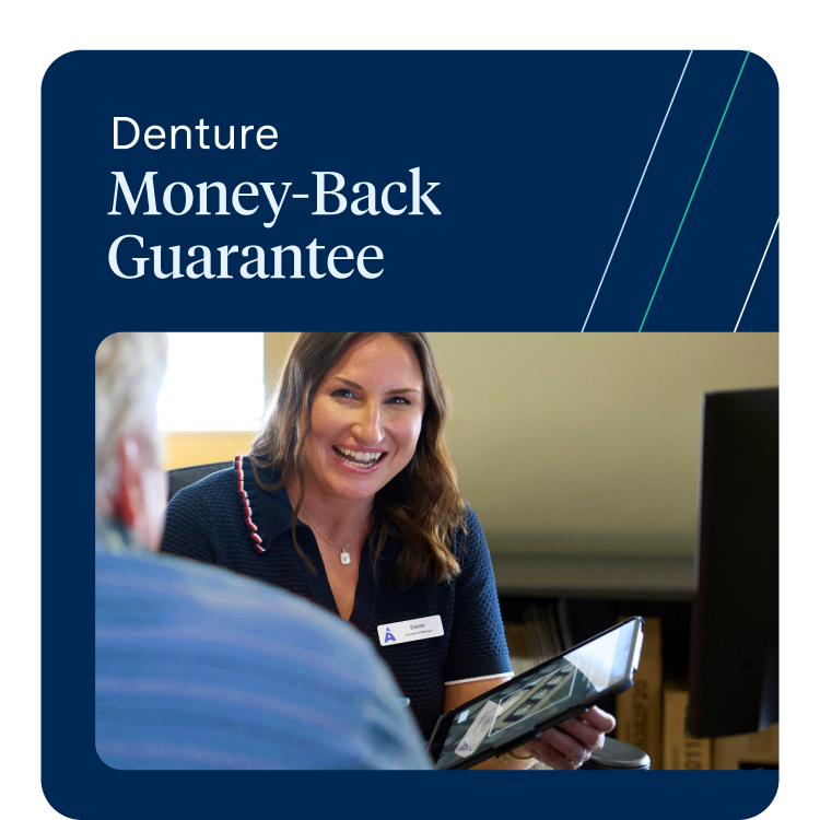 A smiling female Aspen Dental team member named Sarah shows a tablet to a male patient across a desk. The background text advertises the "Denture Money-Back Guarantee."