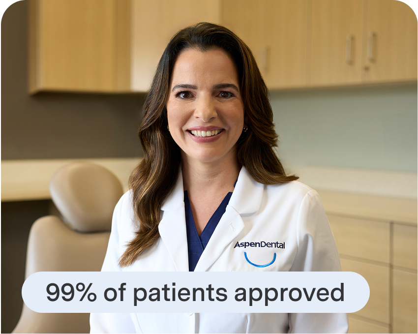  Aspen Dental team member explains financing approval rates to a patient exploring dental implant treatment.