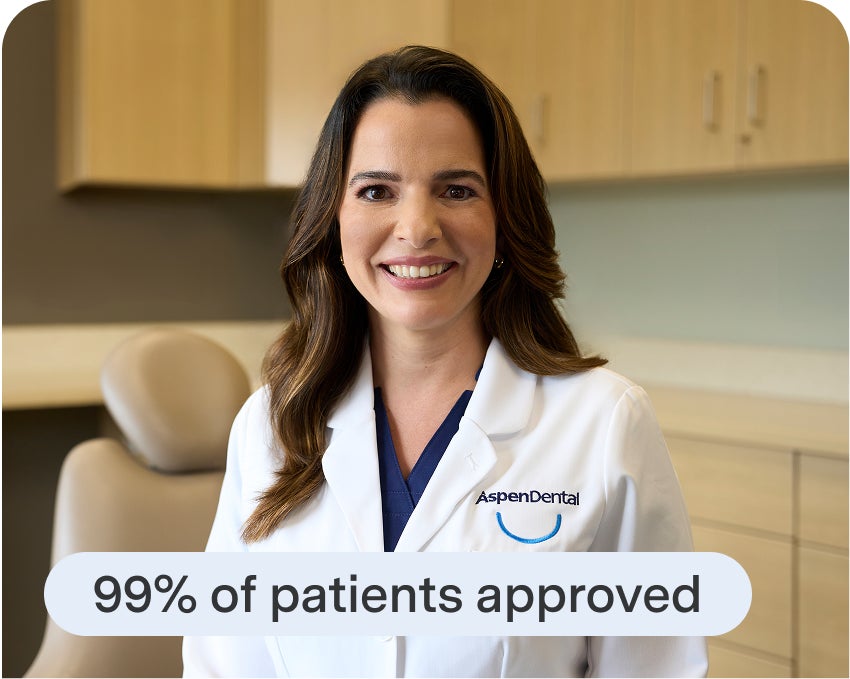  Aspen Dental team member explains financing approval rates to a patient exploring dental implant treatment.