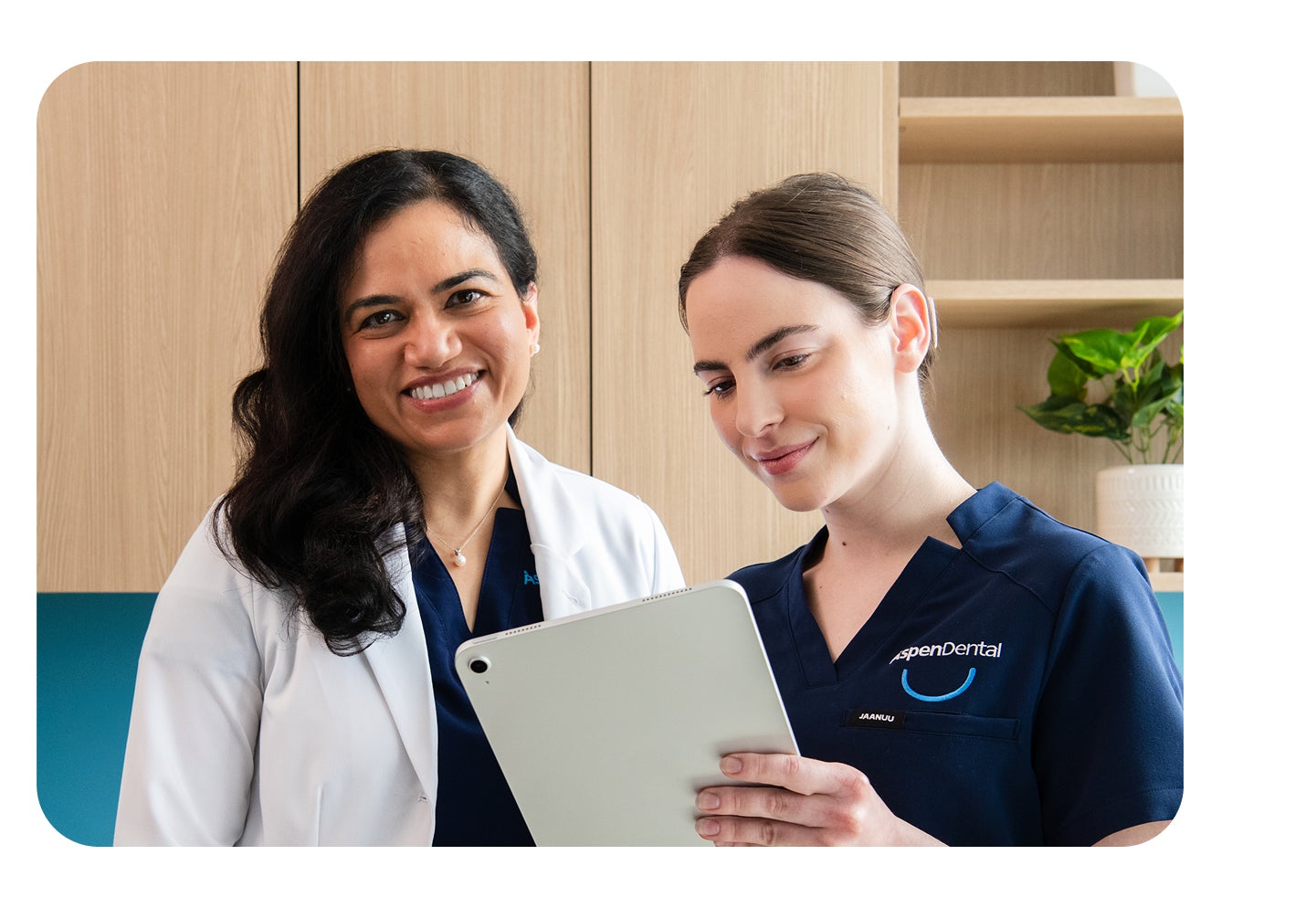 Two Aspen Dental providers collaborating on a tablet, symbolizing the strength of Aspen Dental partnerships in supporting providers and patients.