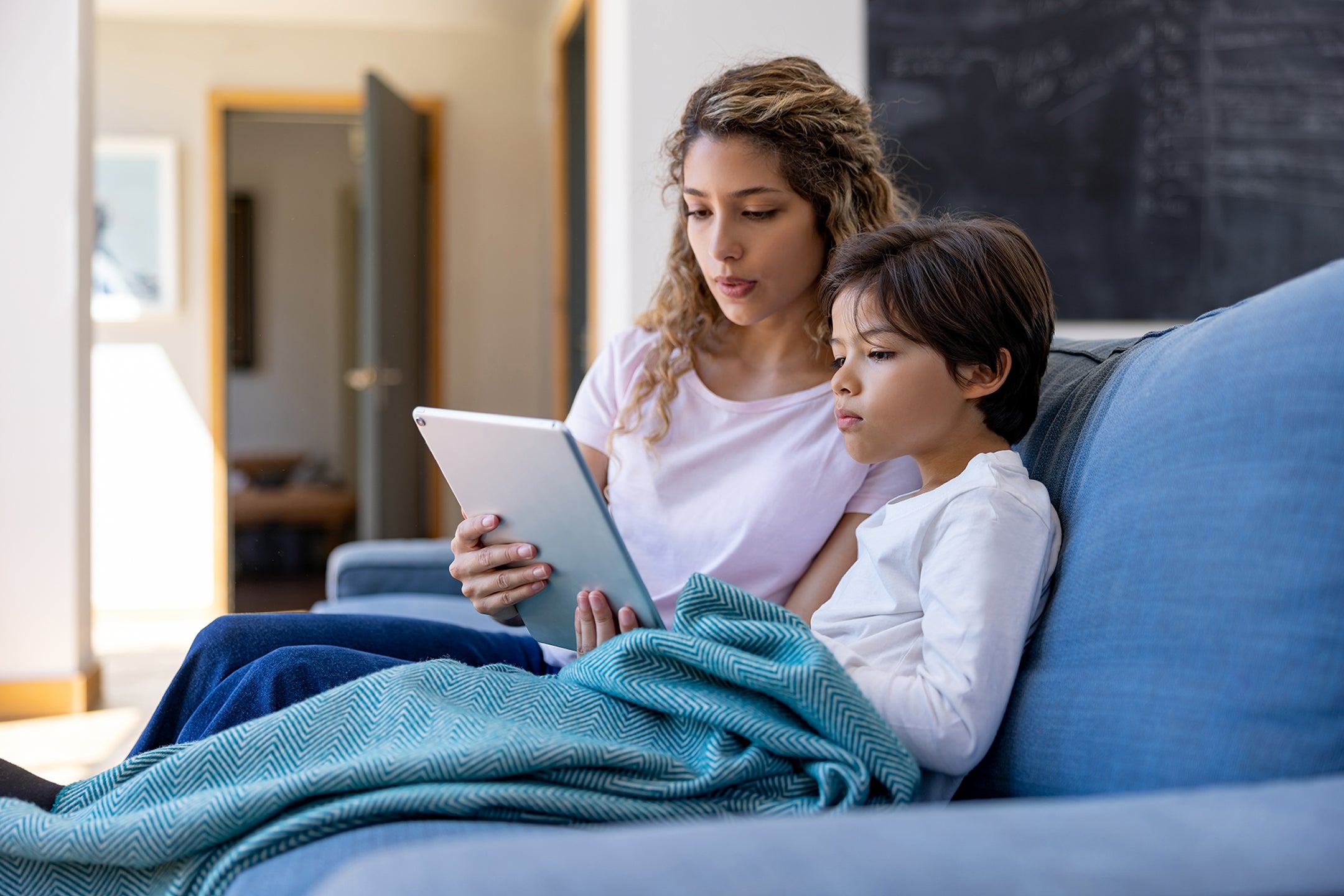 Parent and sick child are having a virtual care visit on a tablet.
