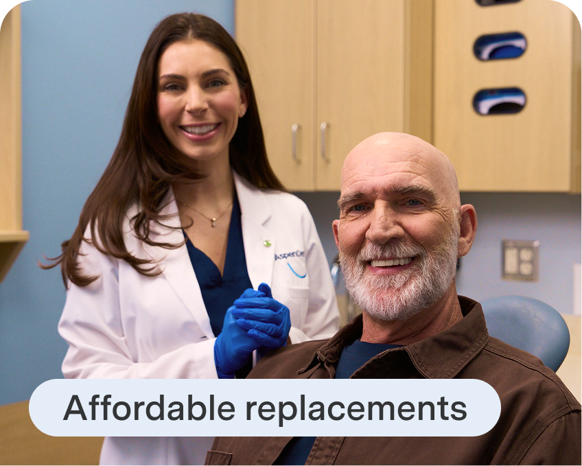 Aspen Dental professional stands beside an older patient in the treatment room, showcasing affordable denture replacement options.