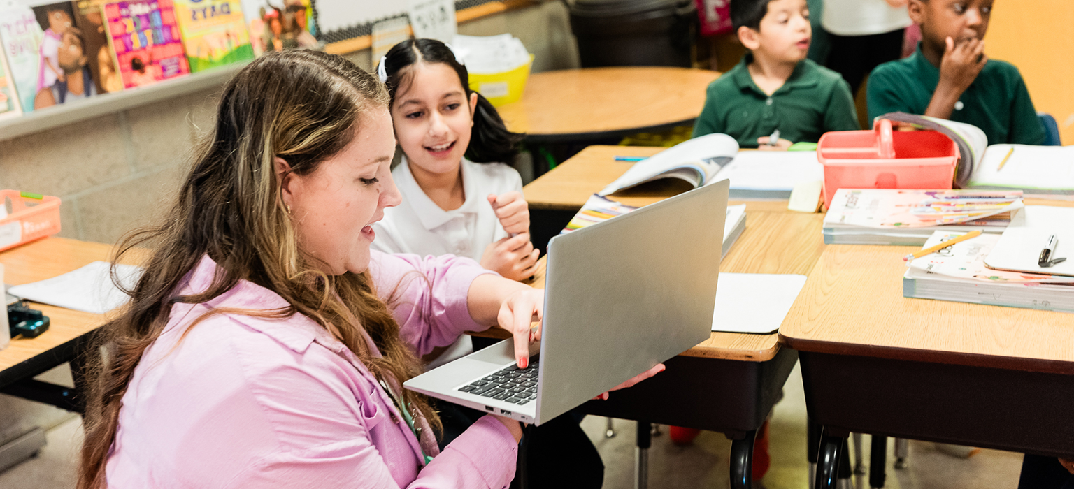 Two young students partner together in a classroom.