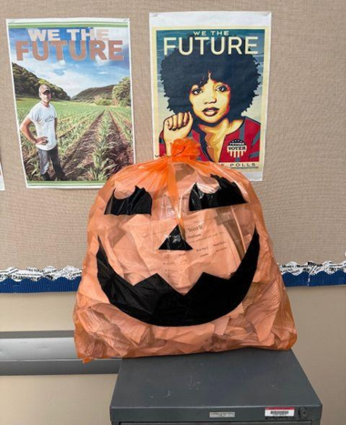 A pumpkin-faced garbage bag filled with recycled paper.