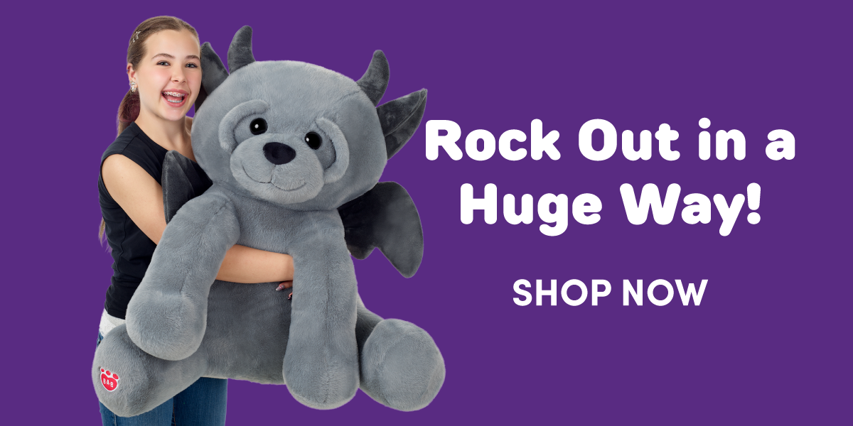 Rock Out in a Huge Way! A person holds a giant gray gargoyle plush with dark gray horns, wings, and paws against a purple background, highlighting its oversized scale. Text reads: Rock Out in a Huge Way! SHOP NOW.