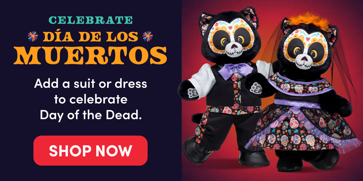 CELEBRATE DÍA DE LOS MUERTOS. Two black cat plush characters with colorful Día de los Muertos-inspired face designs are dressed in festive outfits, including a suit with a purple bow tie and a patterned dress with purple accents and a veil, against a vibrant purple and red background. Text reads: CELEBRATE DÍA DE LOS MUERTOS. Add a suit or dress to celebrate Day of the Dead. SHOP NOW.