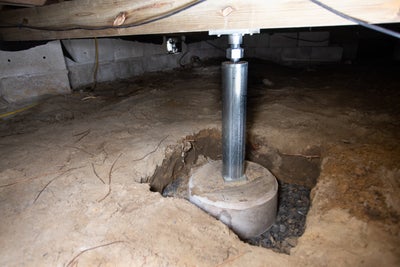 Crawl space jack and its concrete base.
