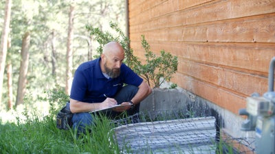 Groundworks inspector assessing a home's exterior wall