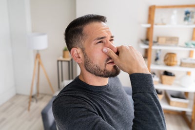 Man holding nose cllosed.