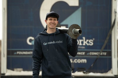Groundworks employee holding a pier, ready to help