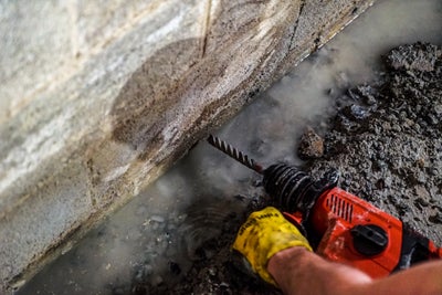 An interior drain getting installed in a basement that has a lot of groundwater