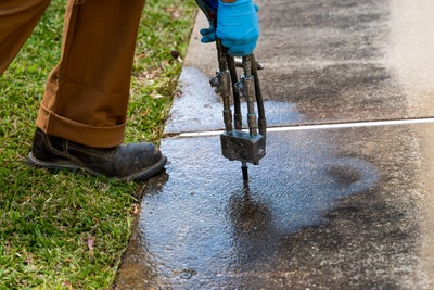 Close up of CFI worker utilizing PolyRenewal for repair on a sidewalk.