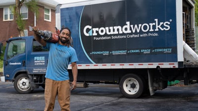 worker holding jackhammer in front of Groundworks truck