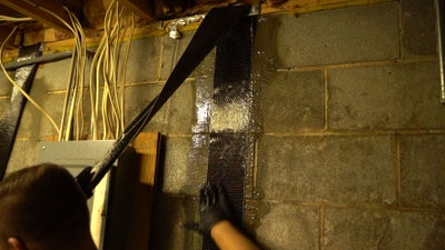 installing carbon fiber straps to fix foundation cracks