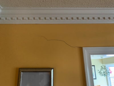 Crack in yellow drywall.
