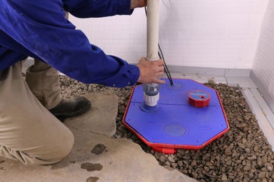 A Groundworks professional installing a sump pump to ensure the basement stays dry and free of water.
