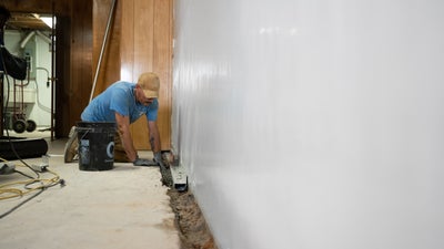 placing interior drains in a basement floor trench