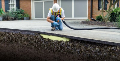 A Groundworks professional lifting a tilted surface to make this home a safer area.