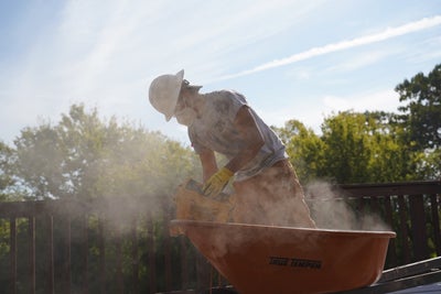 crew member bag of concrete wheelbarrow
