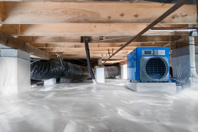 Fully encapsulated crawl space with a vapor barrier and dehumidifier in frame.