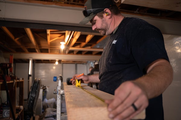 crew measures wood for framing