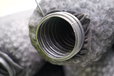 Close up of a drainage pipe wrapped in a silt sock.