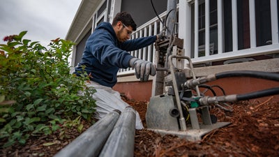 crew member installing push piers foundation repair
