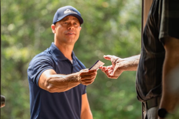 foundation repair expert handing business card to homeowner