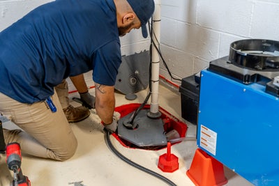 employee inspecting the basement sump pump