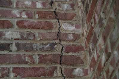 Long vertical crack in a brick wall.
