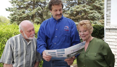 FSM employee reviewing crawl space system with customers.