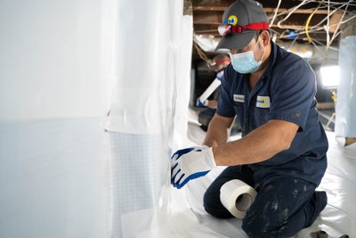 Dry Pro technician installing vapor barrier in a crawl space.