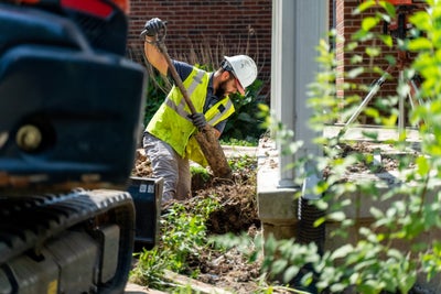 A Groundworks worker using a shovel while a project is in progress.